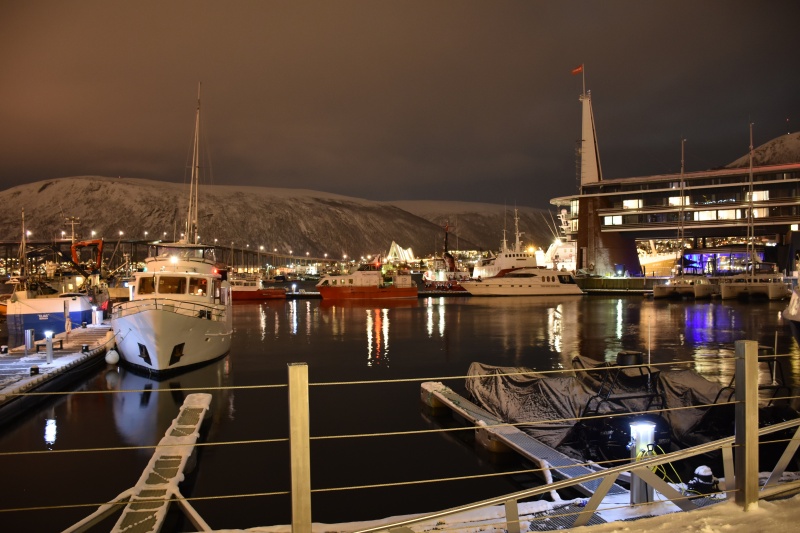 Eindrucksvolle Lichtstimmung im Hafen. Im Mittelpunkt steht die berühmte Eismeerkathedrale. Vom linken Bildrand her arbeitet sich die Tromso Bru auf die in den sechziger Jahren errichtete Kirche zu. Rechts ist das Scandic Ishavhotel (baulich sehr interessant) zu sehen.